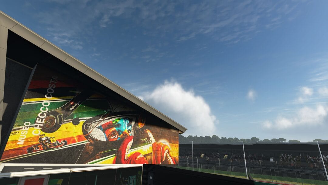 A detailed in-game shot of the Senna mural at Imola Circuit in Assetto Corsa EVO, located near the Variante Tamburello. The mural honors Ayrton Senna with vibrant colors and lifelike artistry, set against the backdrop of the iconic racetrack