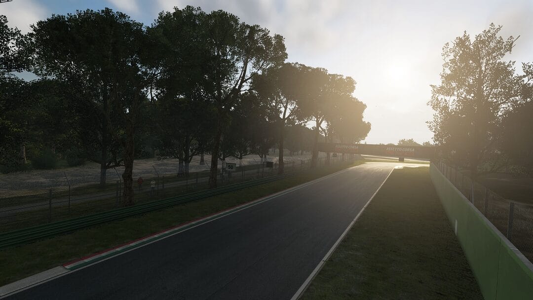 A sunset view of the Imola Circuit in Assetto Corsa EVO, highlighting the smooth track surface and the warm lighting reflecting off the surrounding scenery