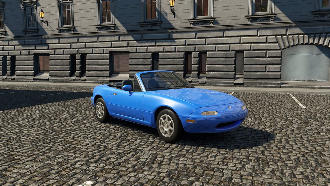 A light blue Mazda MX-5 NA captured in an urban environment in Assetto Corsa EVO Release 0.2. The beloved first-gen Miata brings playful, balanced driving with customizable parts now included in-game.
